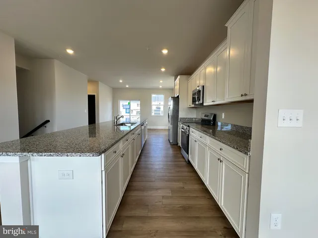 a large kitchen with granite countertop lots of counter space and a sink