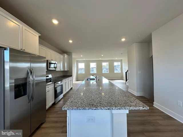 a large kitchen with a center island and stainless steel appliances