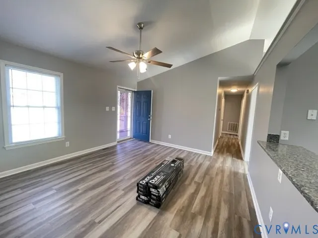 a view of a room with wooden floor and ceiling fan