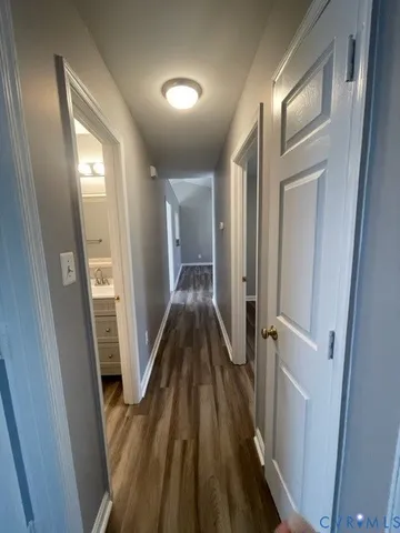 a view of a hallway with wooden floor and staircase