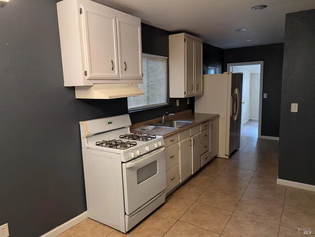 a kitchen with stainless steel appliances granite countertop a stove and a refrigerator