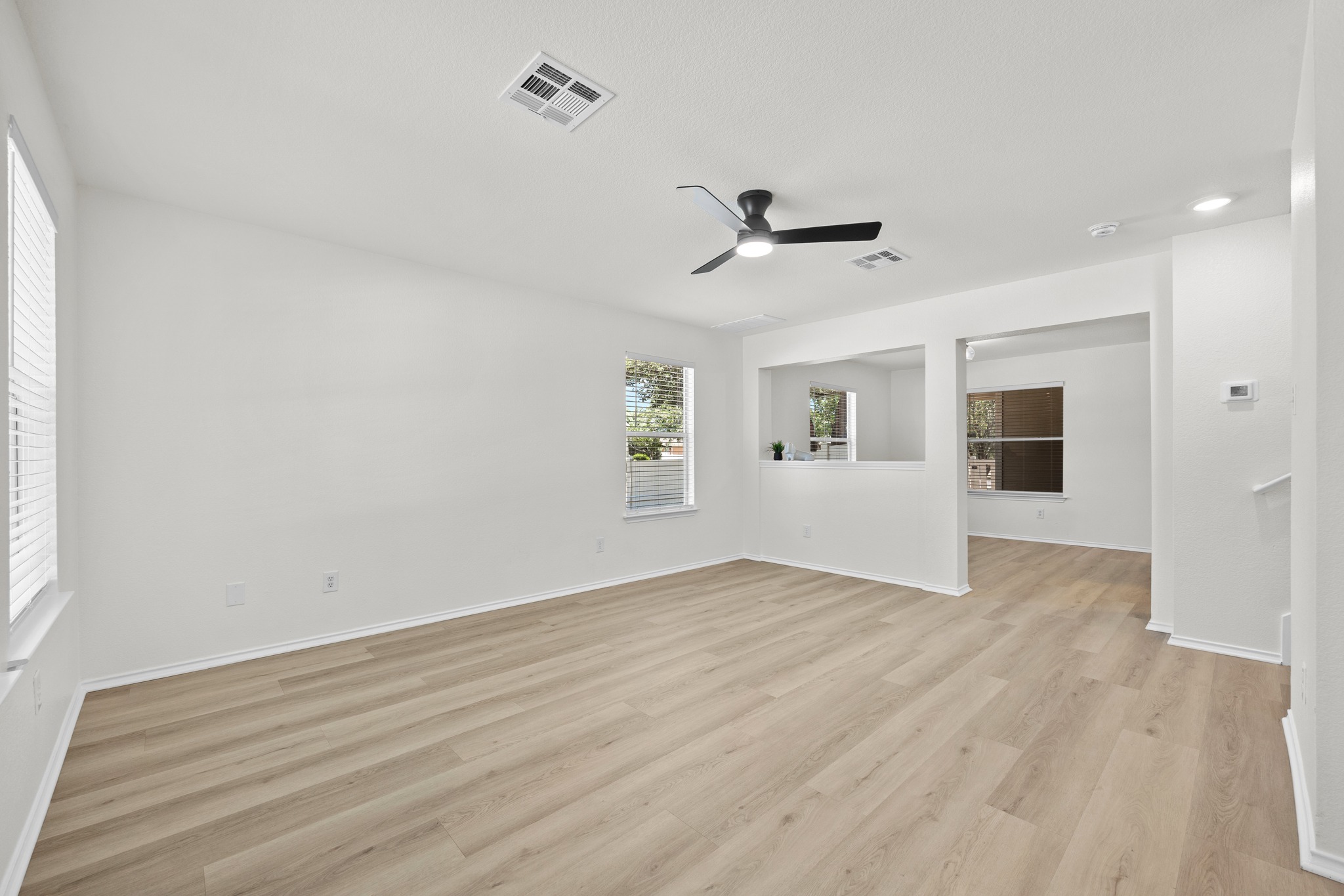 1818 Lost Maples Loop Cedar Park, TX 78613 - Photo 6 of 38 An inviting open-concept living area with light wood-look flooring and a modern ceiling fan.