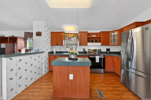 a kitchen with stainless steel appliances granite countertop a refrigerator a stove top oven a sink and dishwasher
