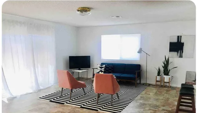 a living room with furniture a rug and a flat screen tv