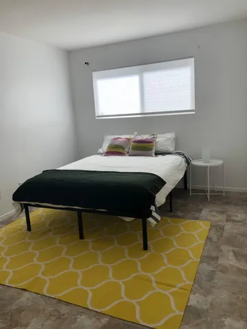 a bed sitting in a room next to a window