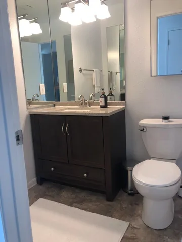 a bathroom with a sink vanity mirror and toilet
