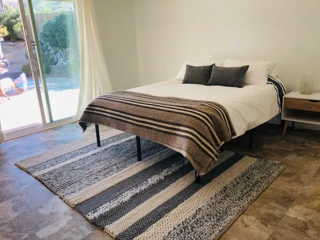 a bedroom with a bed and wooden floor