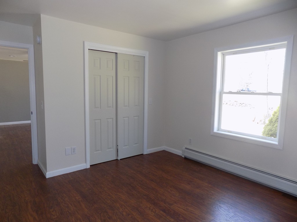 167 Union Road Wales, MA 01081 - Photo 7 of 16 an empty room with wooden floor and windows