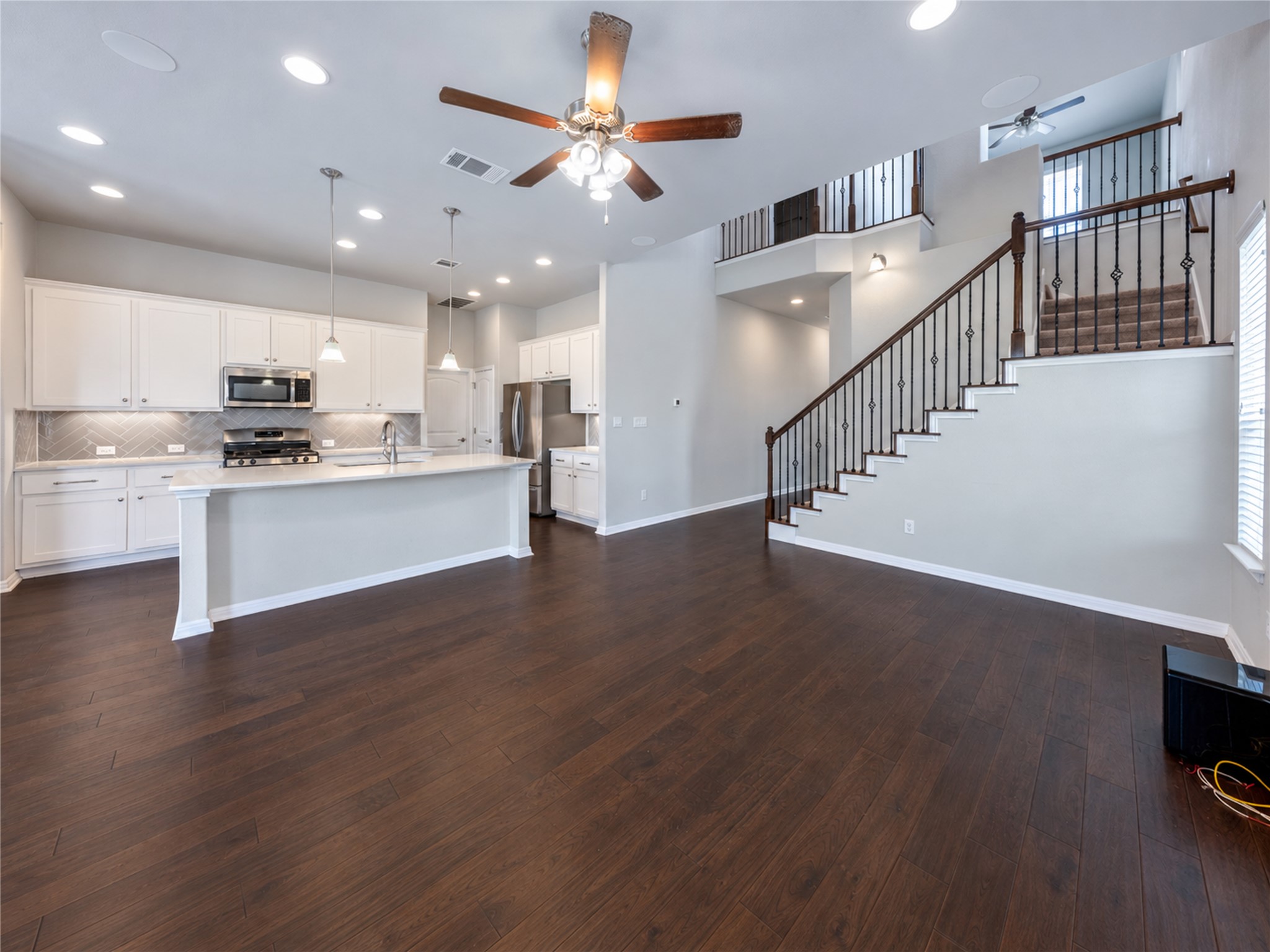 126 Rains Kyle, TX 78640 - Photo 20 of 22 Rich hardwood flooring anchors the spacious open layout beneath high ceilings and a grand staircase.