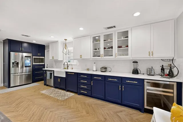 a kitchen with stainless steel appliances kitchen island granite countertop a stove refrigerator and cabinets