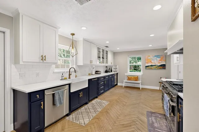a large kitchen with stainless steel appliances granite countertop a sink counter space cabinets and a large window
