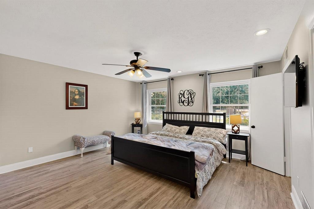 11717 Welch Road Dallas, TX 75229 - Photo 17 of 40 a bedroom with a bed and wooden floor