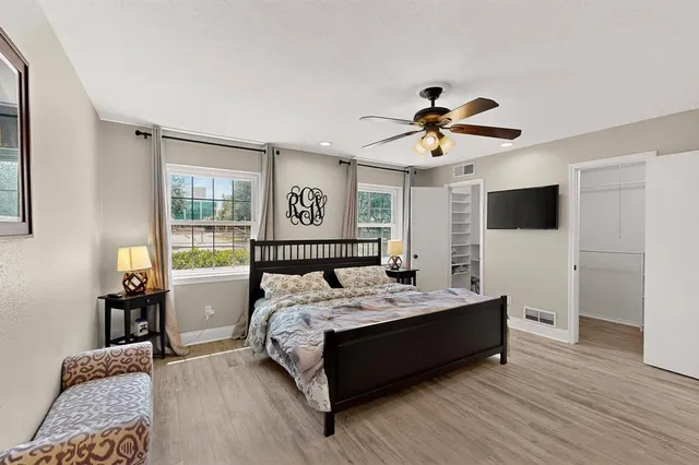 a bed sitting in a bedroom and a flat screen tv