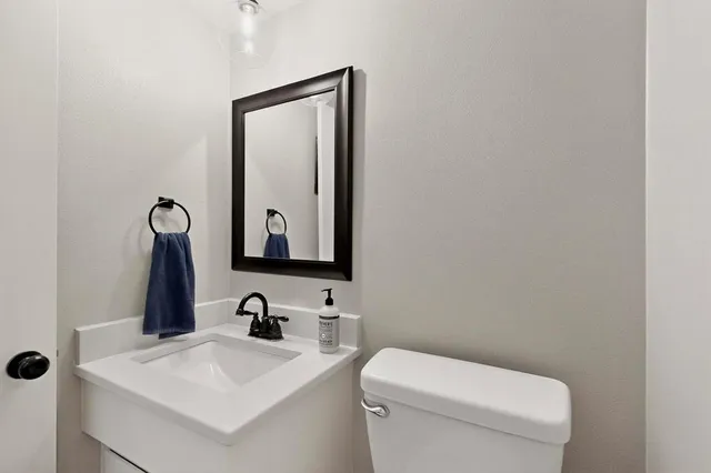 a bathroom with a toilet a sink and mirror