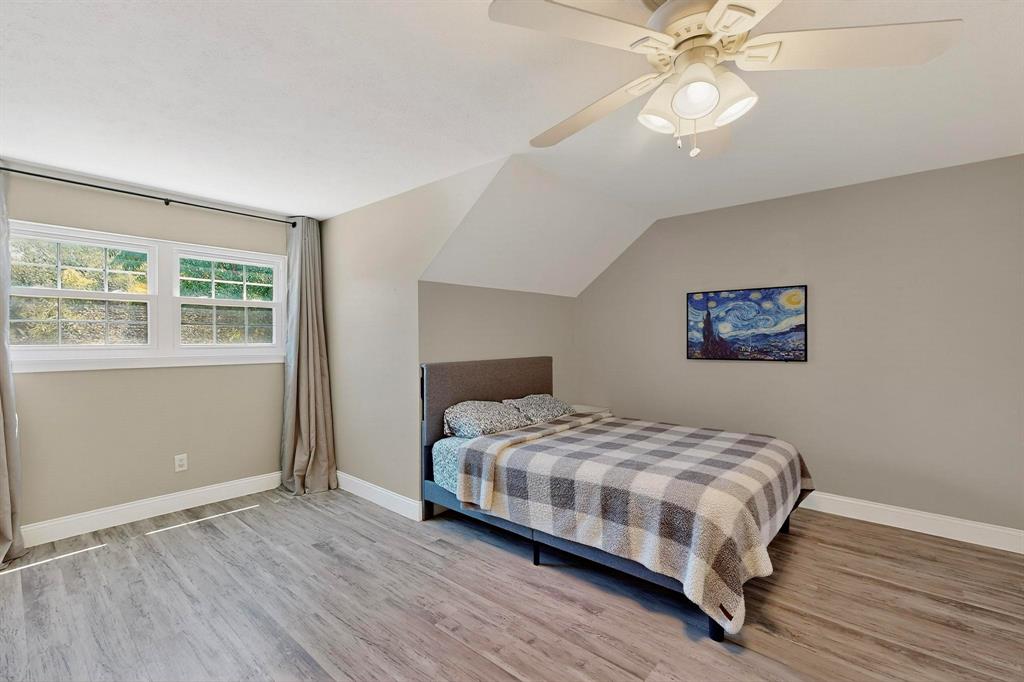 11717 Welch Road Dallas, TX 75229 - Photo 25 of 40 a bedroom with a bed and a chandelier