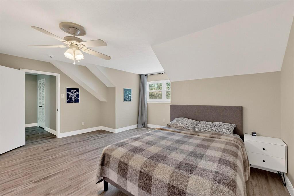 11717 Welch Road Dallas, TX 75229 - Photo 26 of 40 a bedroom with a bed and a chandelier