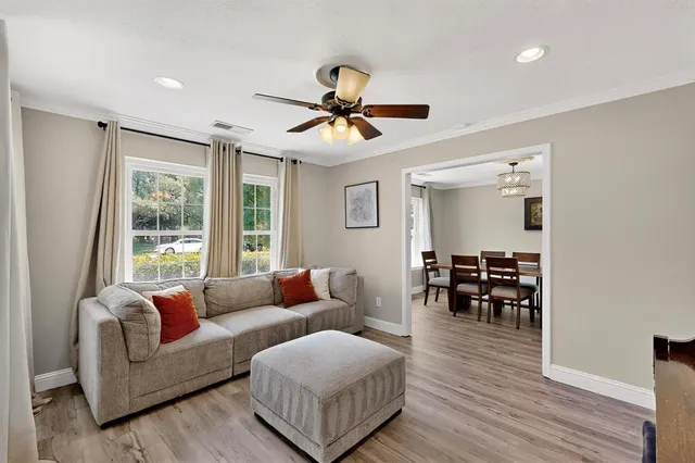 a living room with furniture ceiling fan and a window