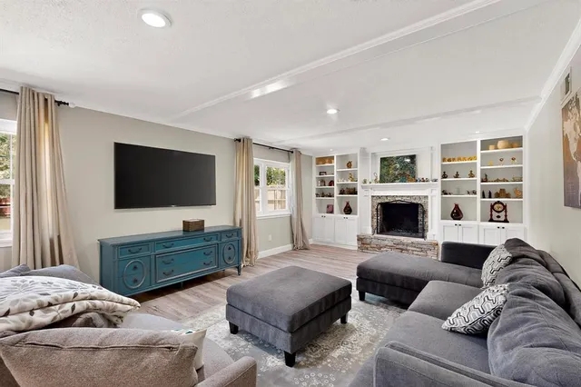 a living room with furniture a flat screen tv and a fireplace