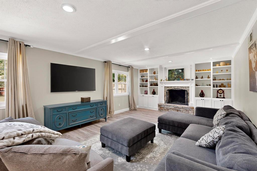 11717 Welch Road Dallas, TX 75229 - Photo 7 of 40 a living room with furniture a flat screen tv and a fireplace