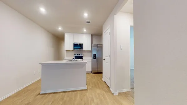 a kitchen with stainless steel appliances a refrigerator and a stove top oven