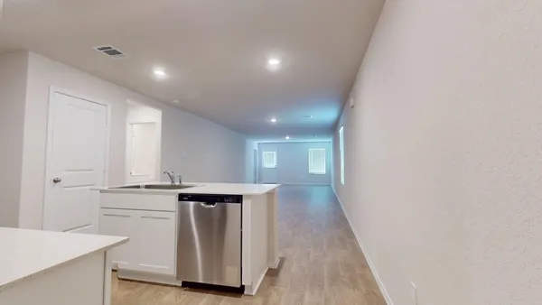 a view of a kitchen with wooden floor and electronic appliances