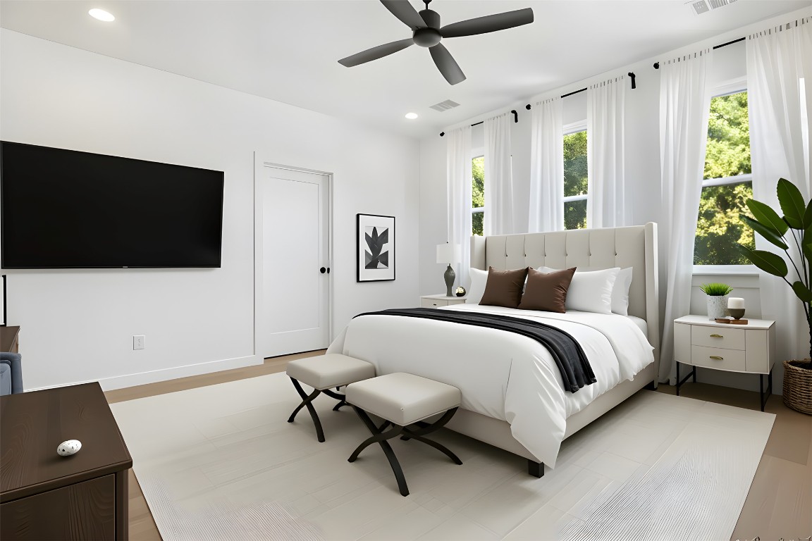 18205 Fair Lane Jonestown, TX 78645 - Photo 22 of 40 a spacious bedroom with a bed and a flat screen tv