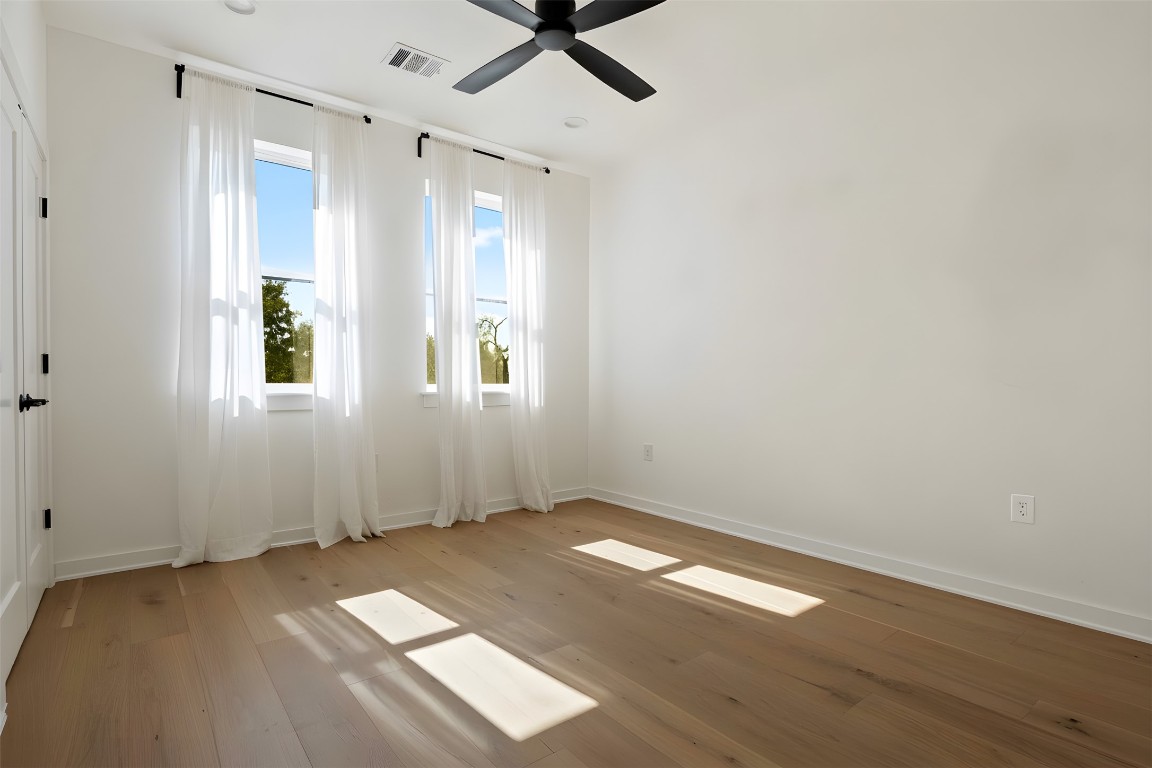 18205 Fair Lane Jonestown, TX 78645 - Photo 31 of 40 an empty room with wooden floor and windows