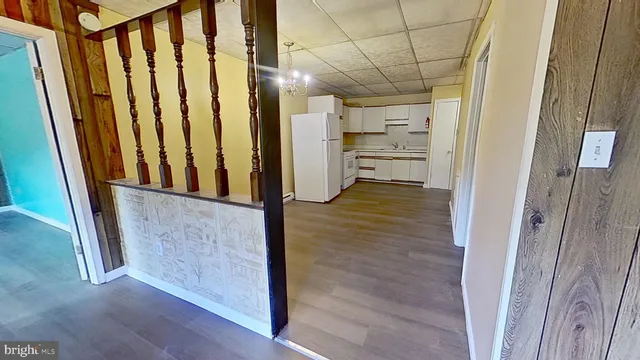 a view of a hallway with wooden cabinet and an empty room