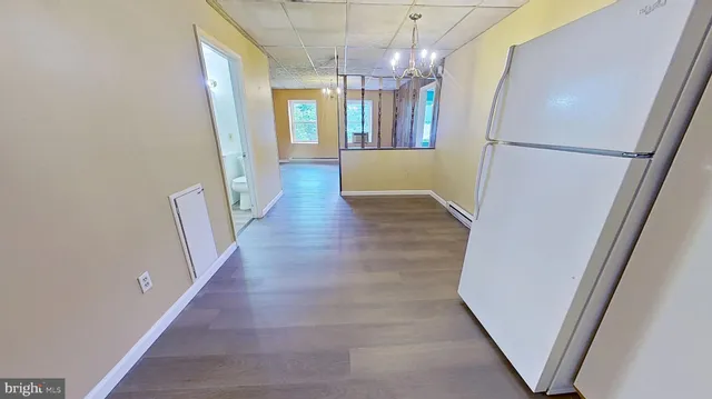 a view of a hallway with wooden floor and chandelier