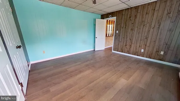an empty room with wooden floor and entrance