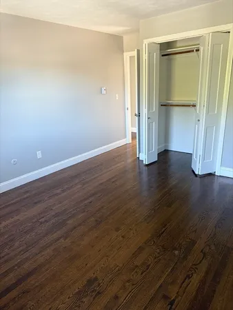 an empty room with wooden floor and closet