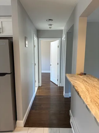 a view of a hallway with wooden floor and staircase