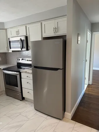 a kitchen with white cabinets and white appliances