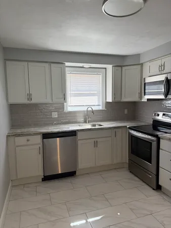 a kitchen with granite countertop white cabinets and white appliances