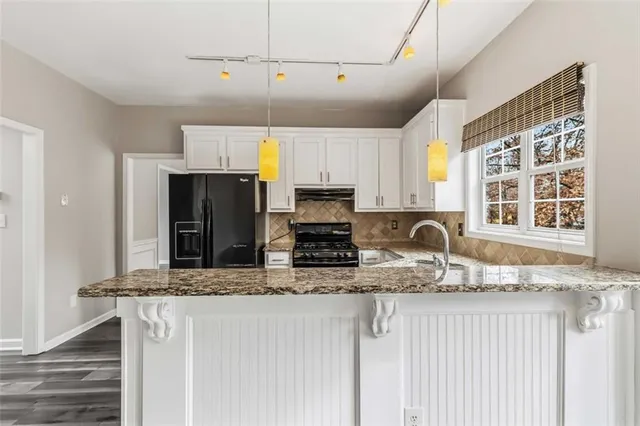 a view of an empty room with wooden floor fireplace and a window