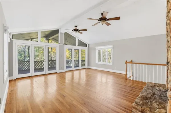 a view of an empty room with a window and wooden floor
