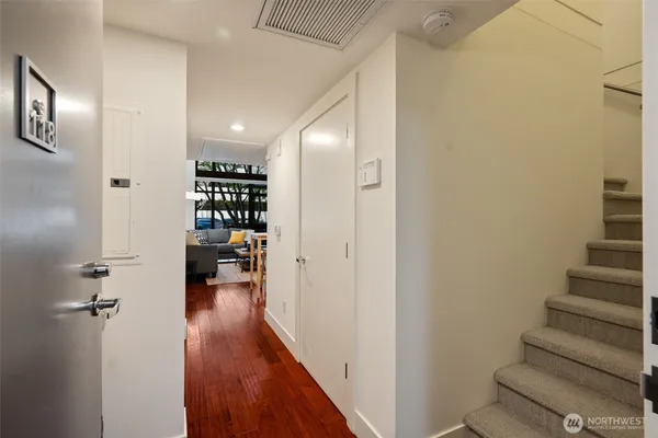 a view of a hallway with wooden floor and staircase