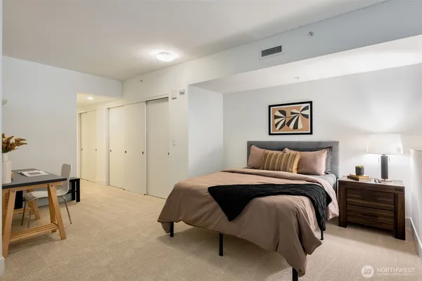 a spacious bedroom with a bed and a cabinets