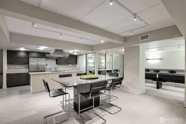 a kitchen with stainless steel appliances kitchen island granite countertop a table chairs in it and wooden floors