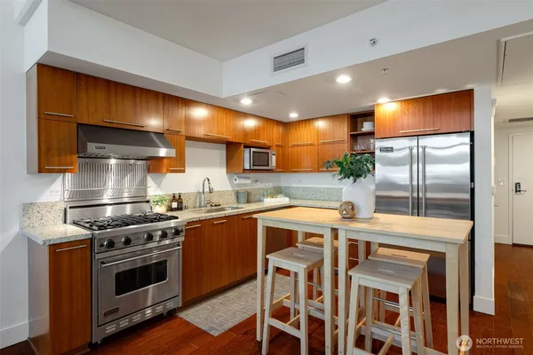 a kitchen with stainless steel appliances granite countertop a stove and a refrigerator