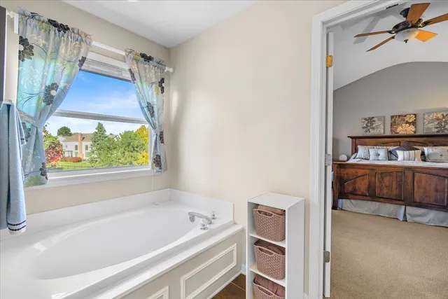 a bathroom with a tub a sink and a window