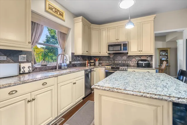 a kitchen with granite countertop a sink window and cabinets