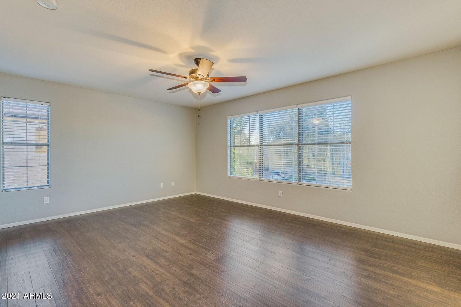 1791 East Del Rio Street Gilbert, AZ 85295 - Photo 13 of 28 an empty room with wooden floor chandelier fan and windows