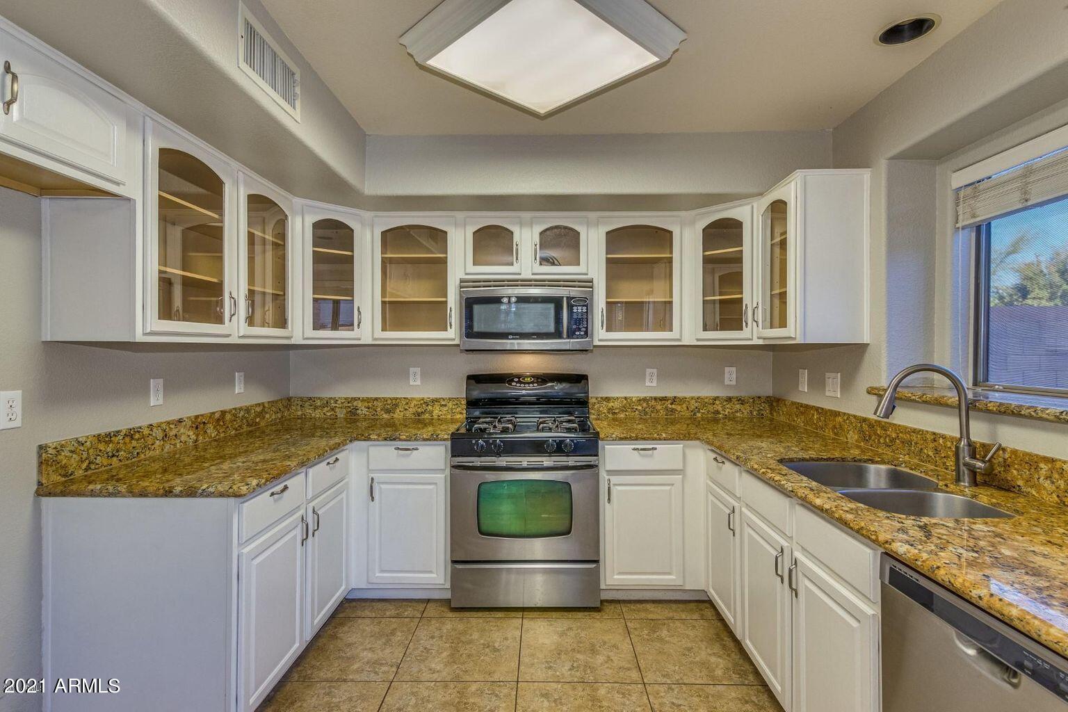 1791 East Del Rio Street Gilbert, AZ 85295 - Photo 6 of 28 a kitchen with stainless steel appliances granite countertop a sink and cabinets