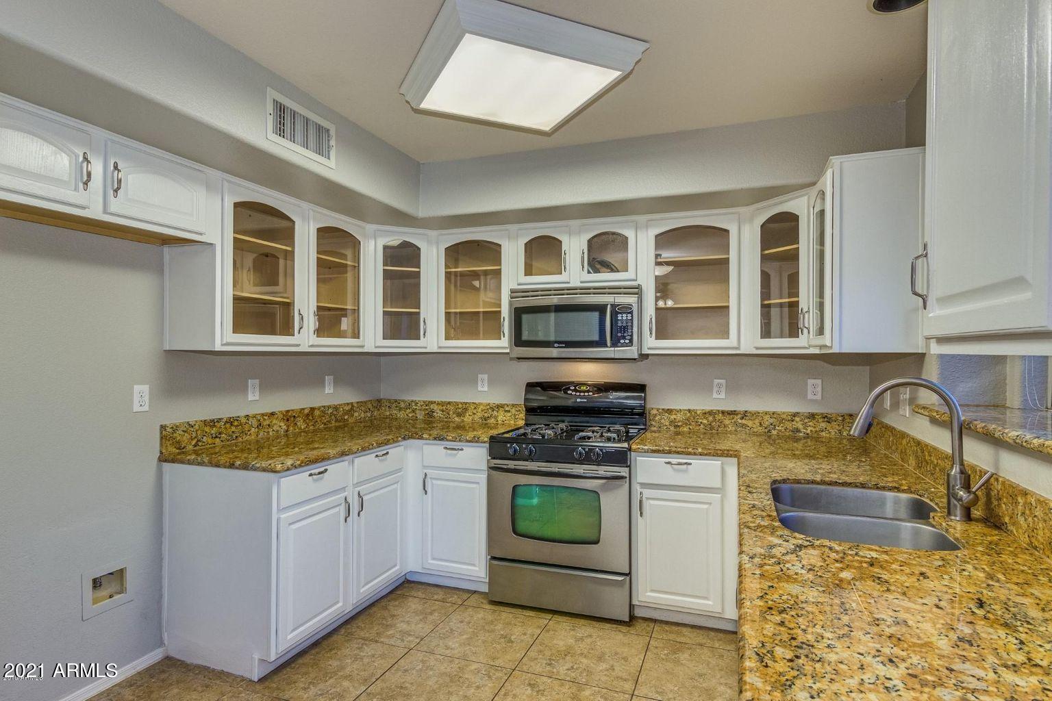 1791 East Del Rio Street Gilbert, AZ 85295 - Photo 7 of 28 a kitchen with stainless steel appliances granite countertop a stove and cabinets