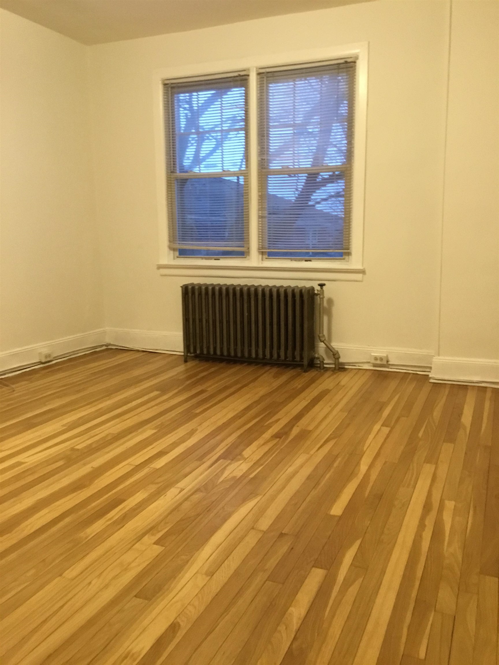 1407 70th Street, Unit 2 North Bergen, NJ 07047 - Photo 13 of 22 a view of an empty room with wooden floor and a window