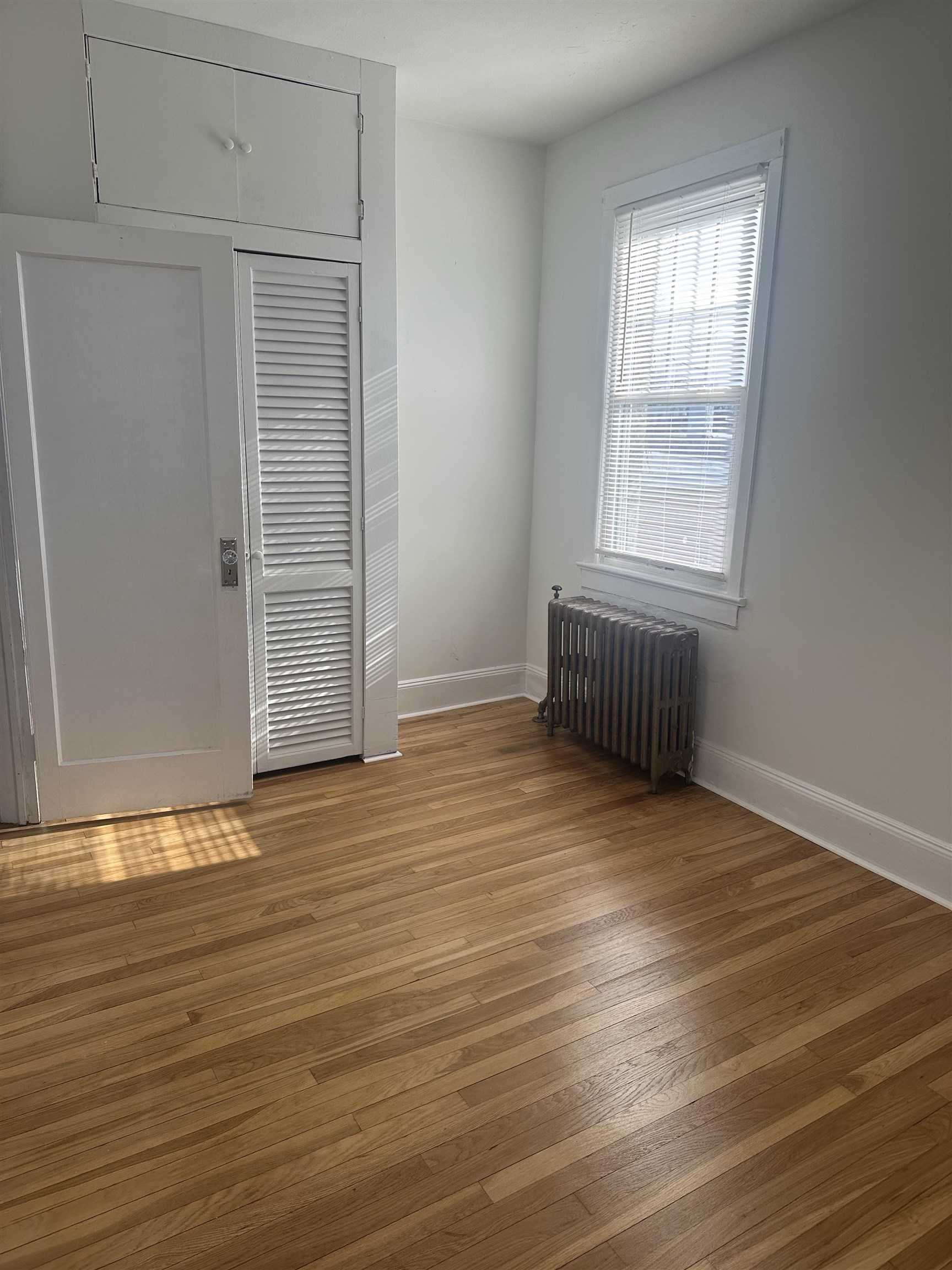 1407 70th Street, Unit 2 North Bergen, NJ 07047 - Photo 15 of 22 an empty room with wooden floor and windows