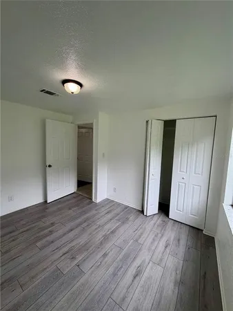 an empty room with wooden floor and entrance