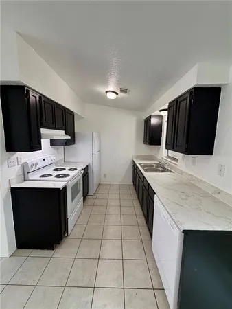 a kitchen with stainless steel appliances a stove a sink and a microwave