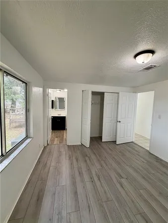 an empty room with wooden floor and windows